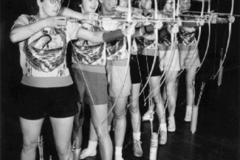 Young women in line with bows drawn.