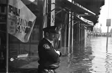 Policeman hip-deep in water, Cambridge flood 1974