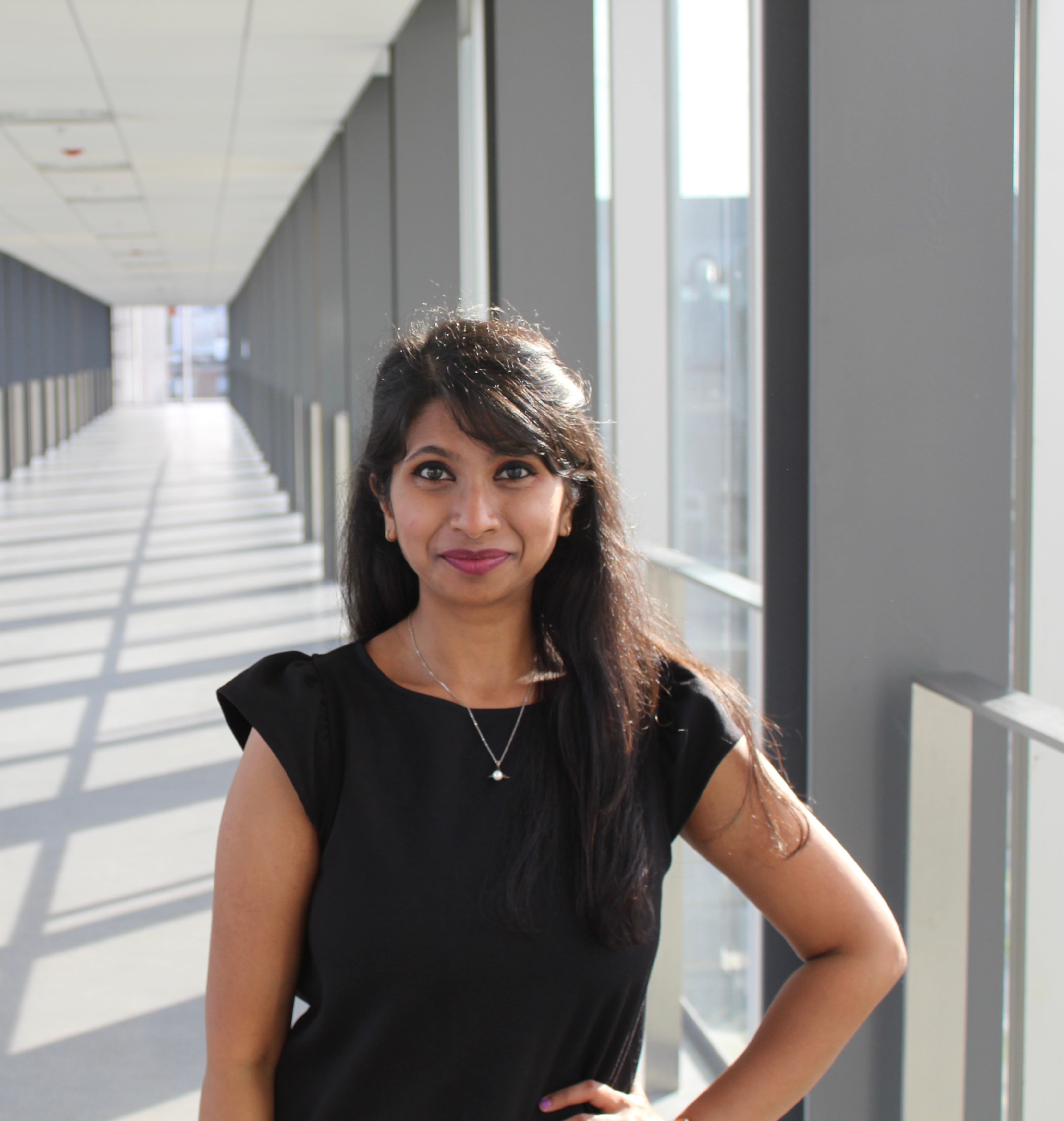 Madhuja stands in the overhead tunnel leading to the E7 building at the Unviersity of Waterloo.