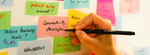 Someone writing on sticky notes