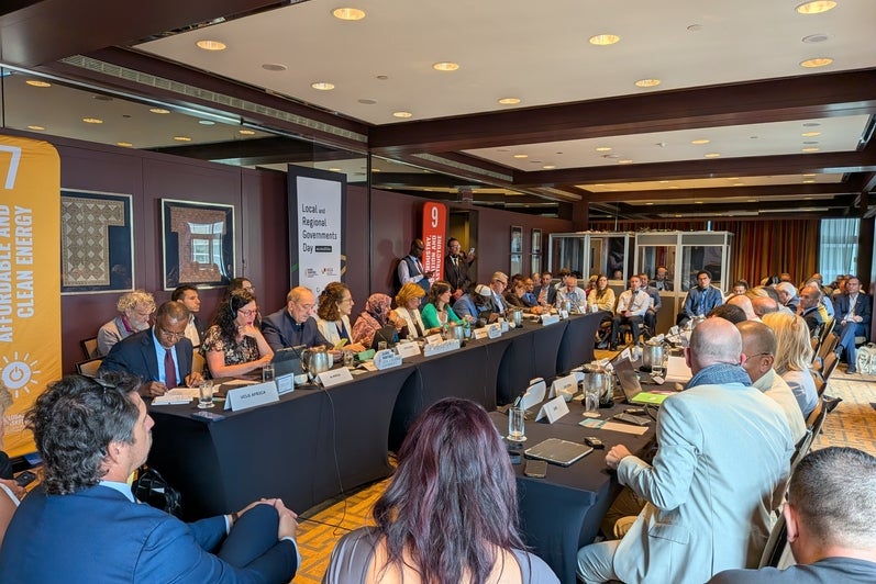 A meeting room with international delegates seated