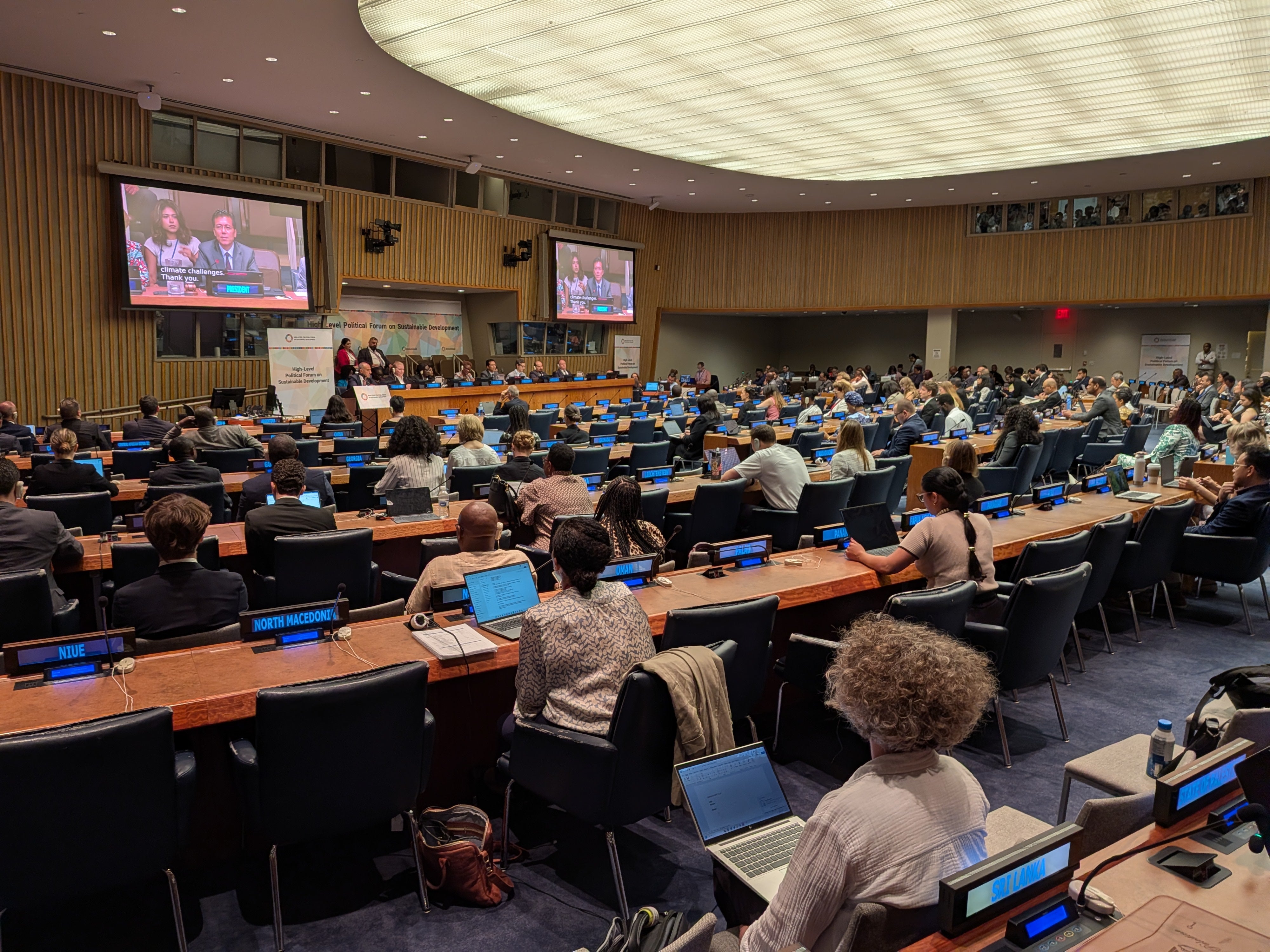 a room of people listening to a presentation at the UN