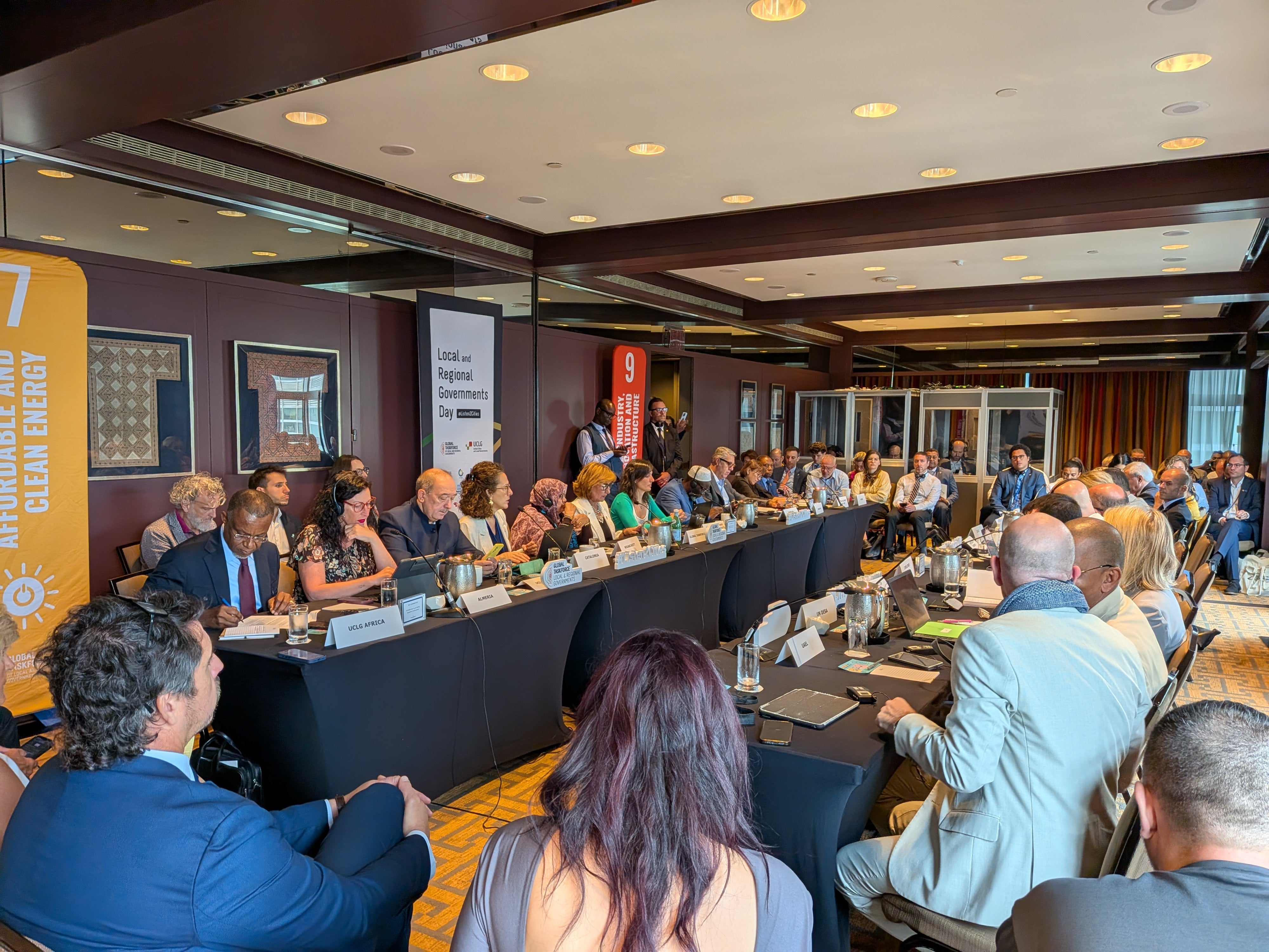 A meeting room with international delegates seated