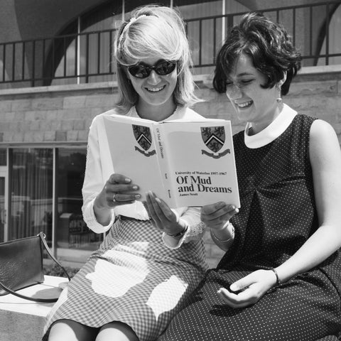 Two women looking at brochure on campus