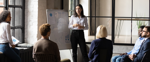 Women teaching a course at the front of a meeting