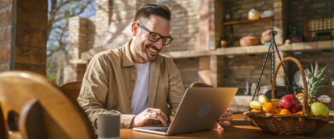 Man smiling and looking at computer at home