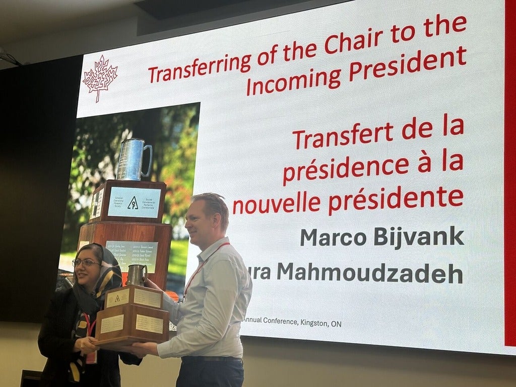 Marco Bijvank handing over the Rivett Mug to new president Houra Mahmoudzadeh 