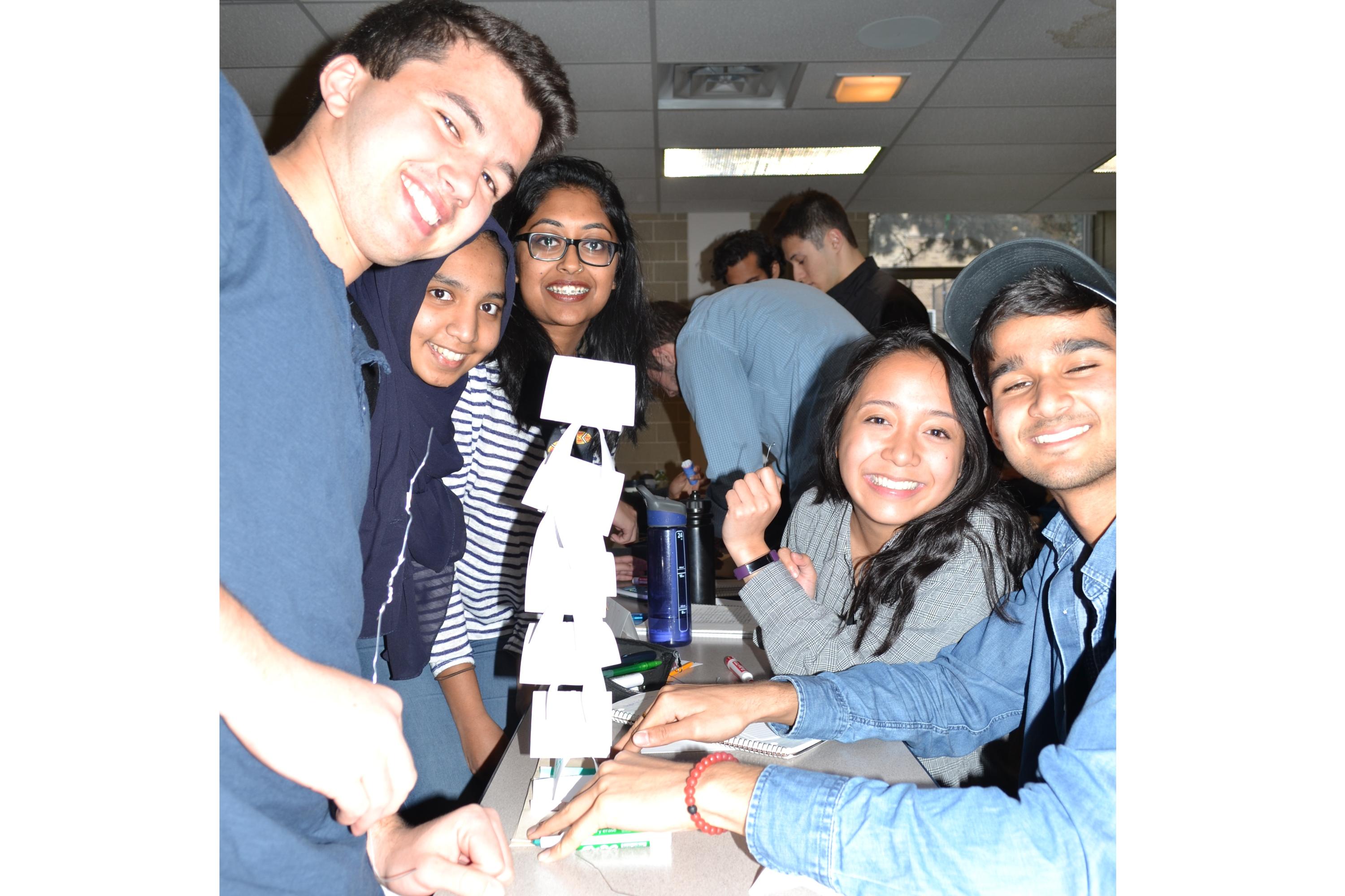 Management Engineering students Yusuf Khaled, Sana Irfan, Sathana Srikanthan, Samantha Villaluz, and Aditya Kalia show off the paper tower they built in one of the class activities in MSCI 211