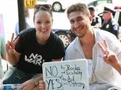 Rachel Anderson sitting with someone holding a sign
