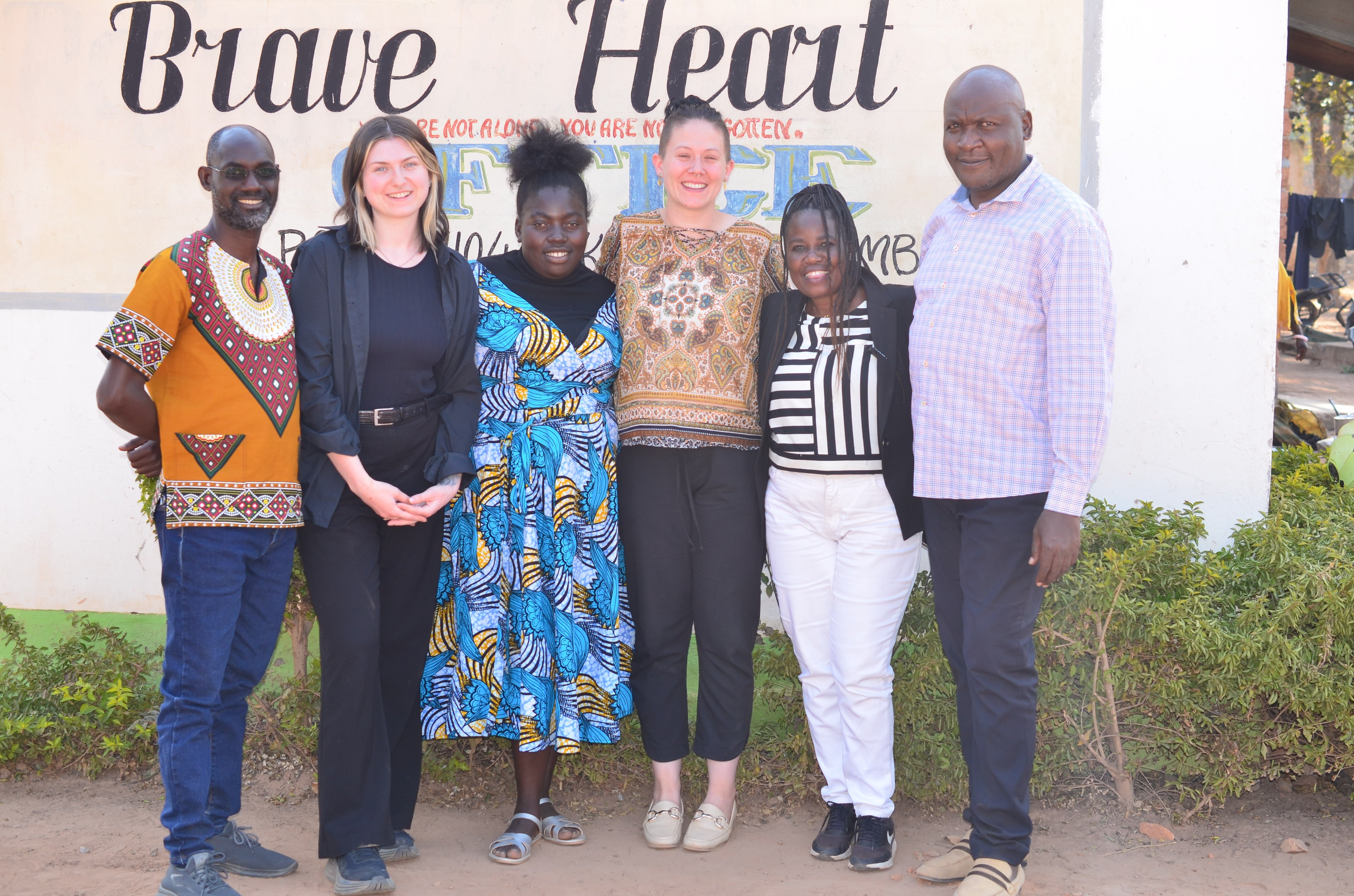 Students with employees in front of the Brave Heart builiding