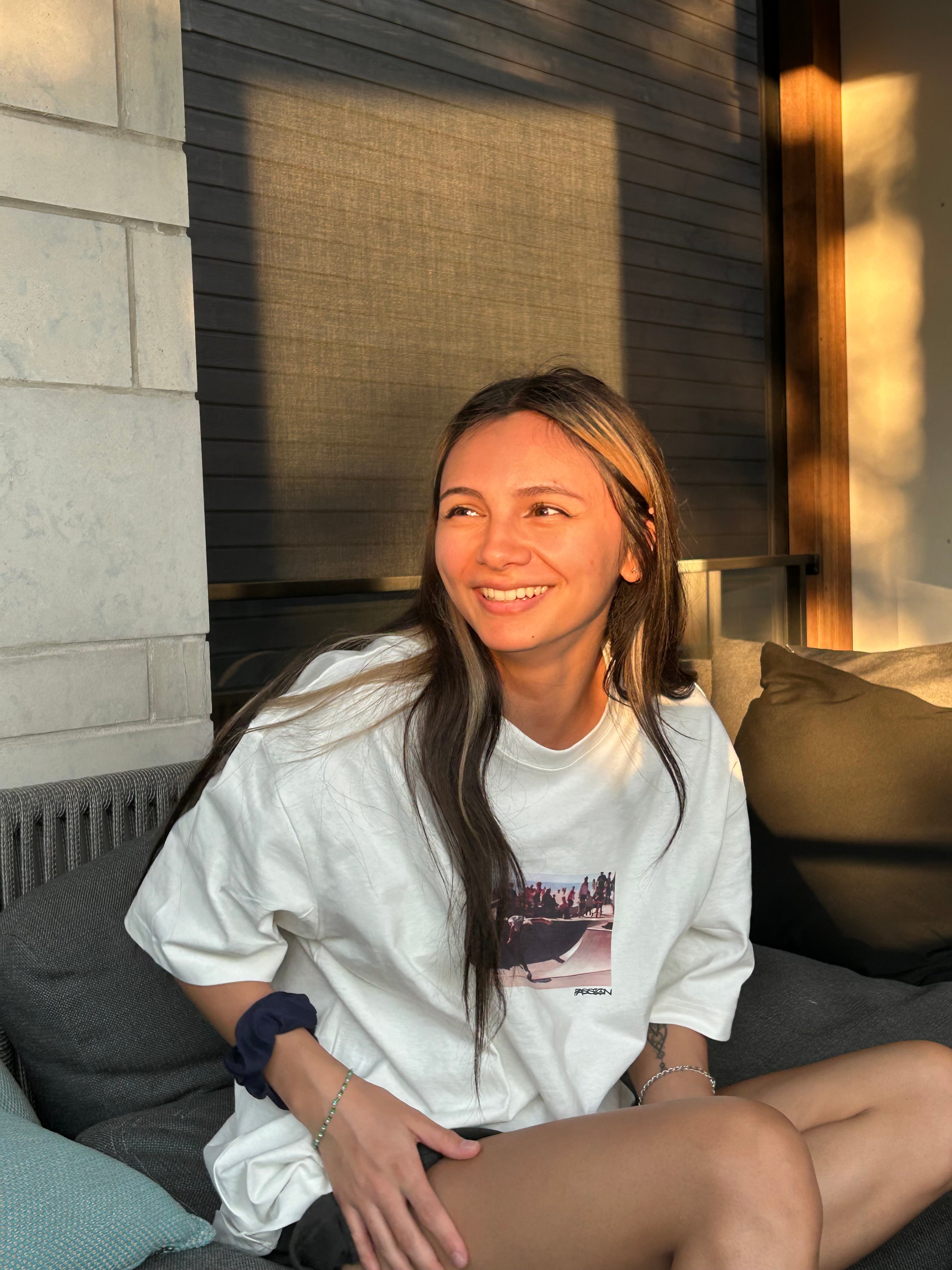 Dylan-Paige Andres smiles while sitting on a porch