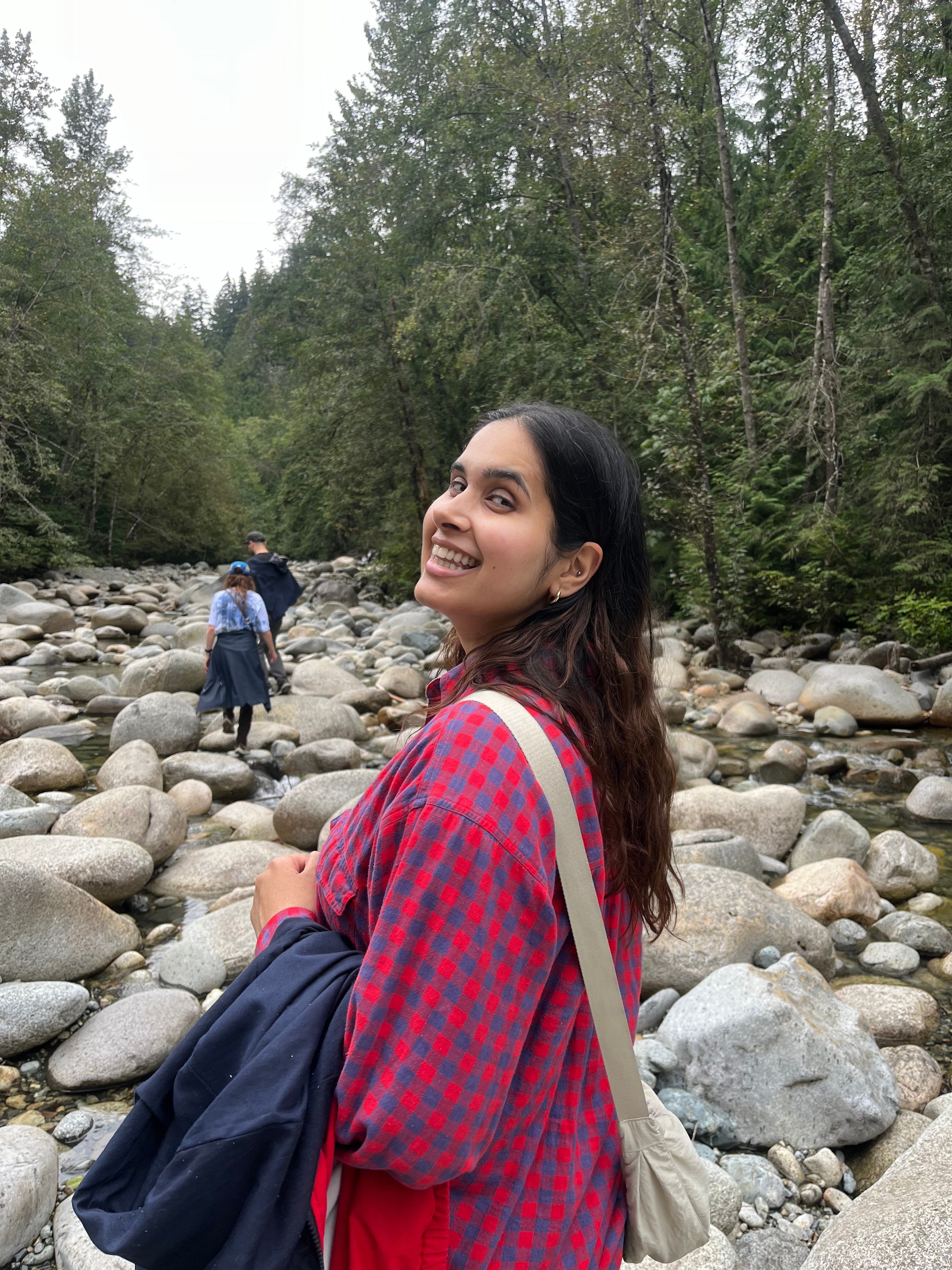 Woman smiling as she is walking through the forest