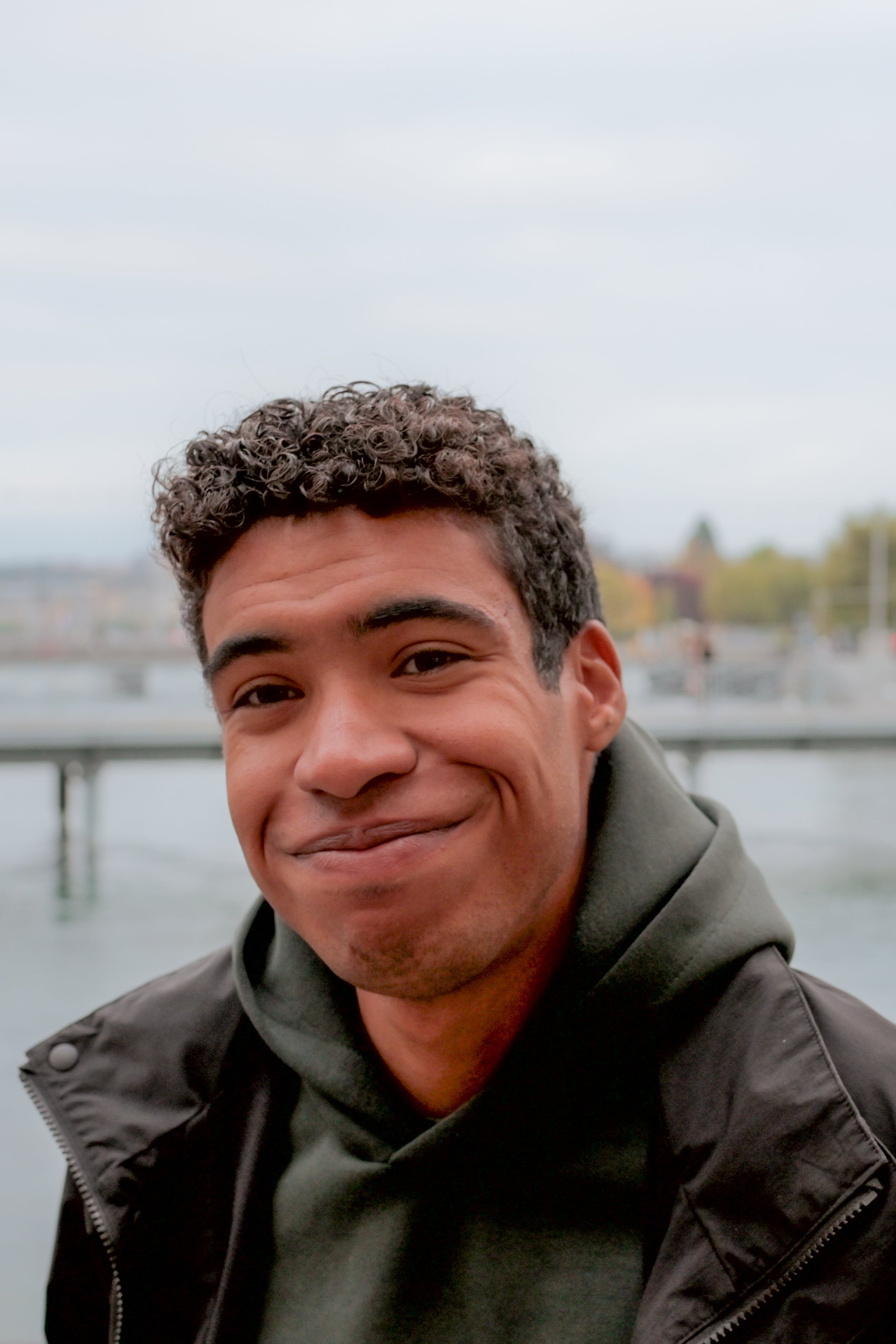Jaden is smiling with a backdrop of water