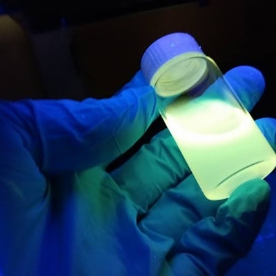 Students holding up quantum dots in gloved hand