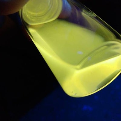 Radiant yellow quantum dot under UV/black light being examined