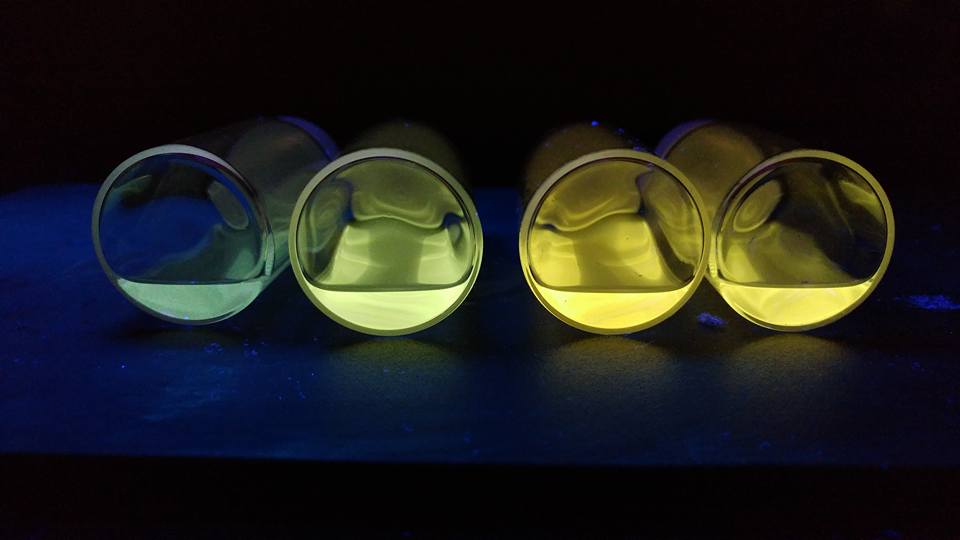 Close up of vibrant blue, green, and yellow quantum dots under UV/black light