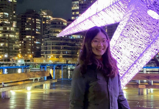 Young woman standing beside a giant star