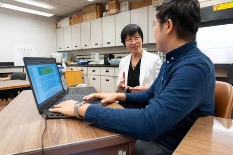 Bing Hu and Helen Chan in front of a computer