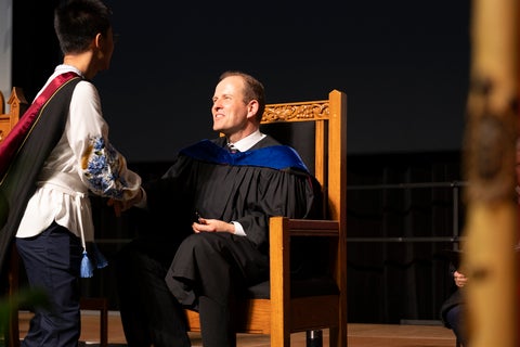 Dean Jochen Koenemann in chair at onvocation, shaking hand of student