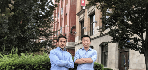 Two men with arms crossed outside of building