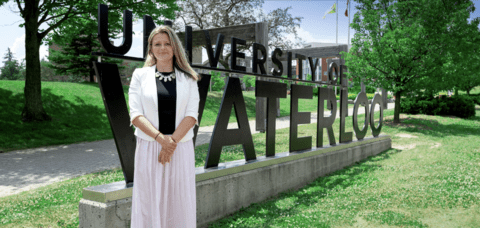 Women standing in front of UW sign