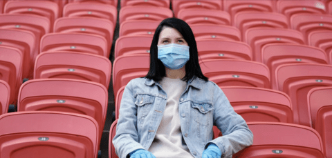 Lady wearing mask on bleachers