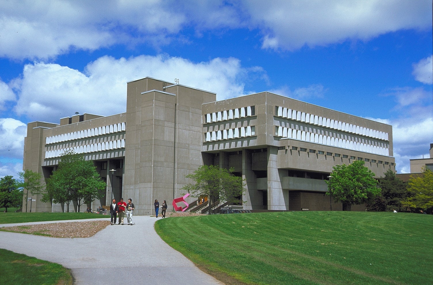 MC building which consists of concrete blocks and windows with green grass and blue sky background