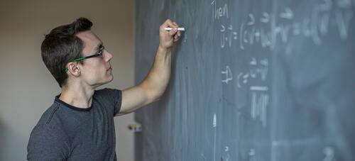 Male writing on a chalkboard