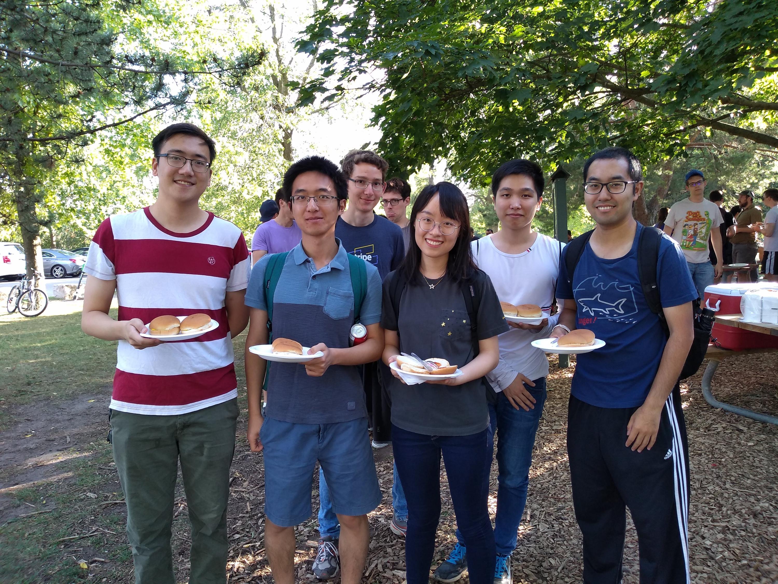 A group of students in the park holding plates