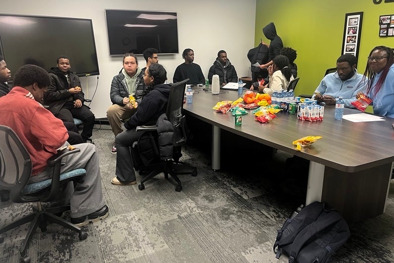 A group of people eating and talking to each other