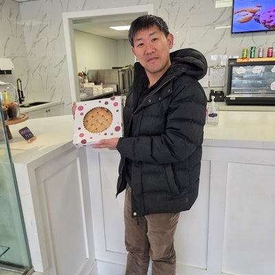 man standing and smiling holding a pie