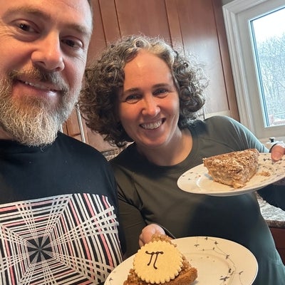 a man and a woman holding plates with pies on them