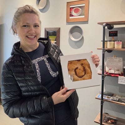 woman standing, smiling with a pie