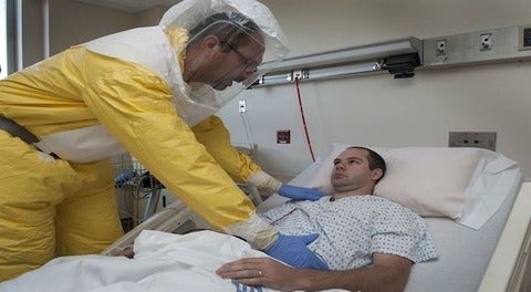 Patient being attended to by medical person wearing protective clothing