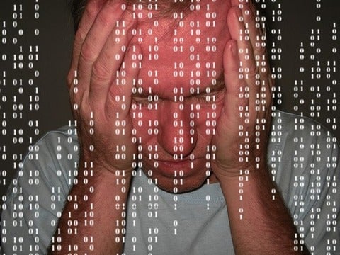 Man looking frustrated with computer codes in the foreground 
