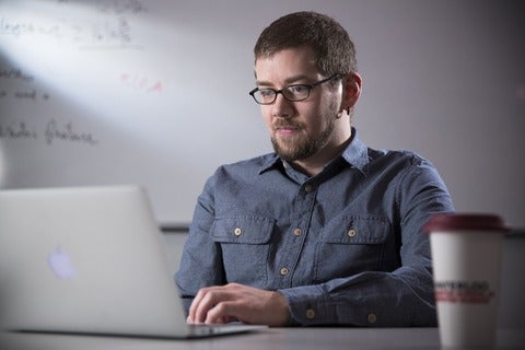 male graduate student on laptop