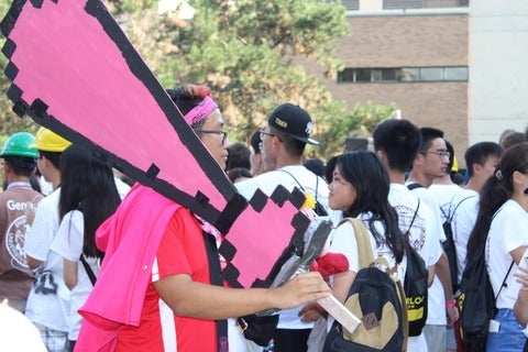 Orientation leader carrying large pink tie sign