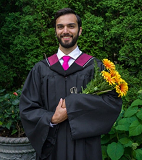 Nicholas Richardson in his convocation gown holding flowers