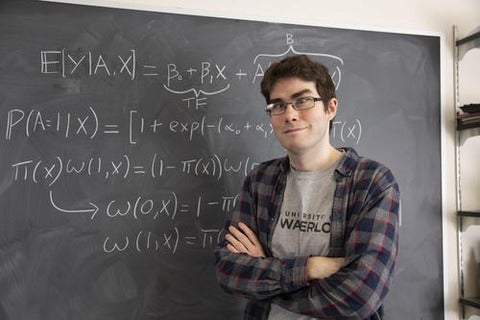 Michael Wallace in front of a blackboard wih equations