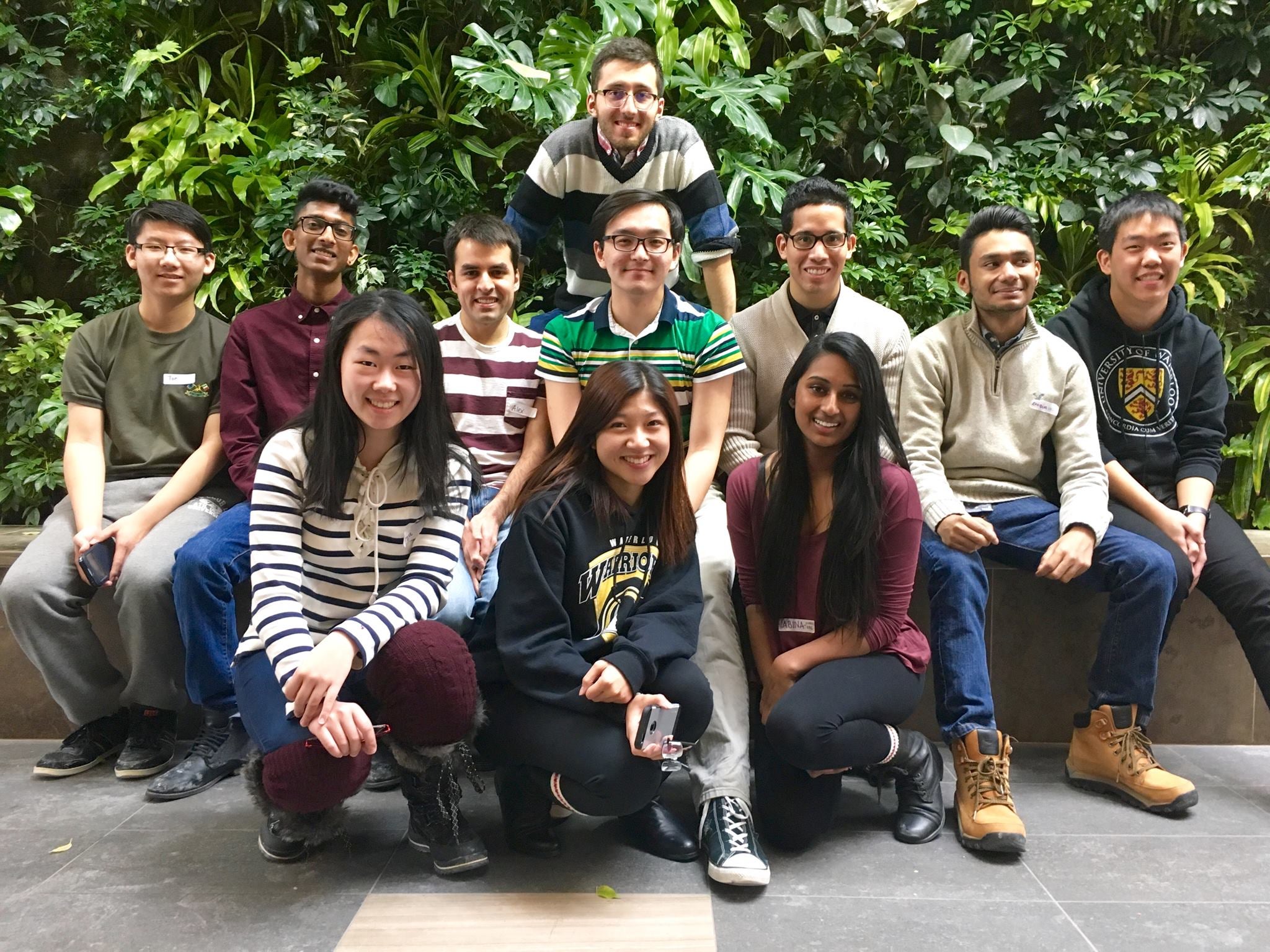 A group of 12 students smiles at the camera