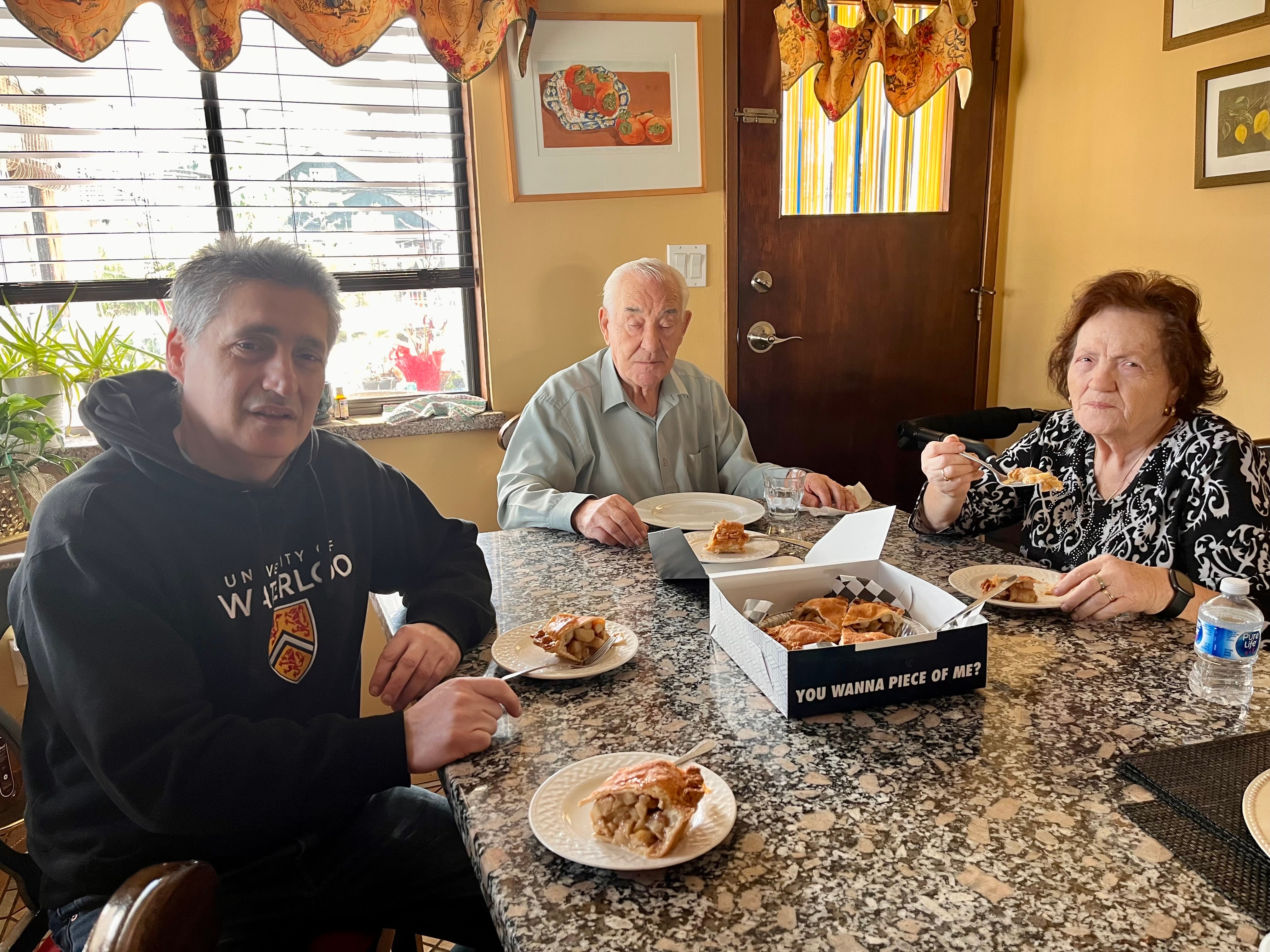 3 people sitting at a table eating pie