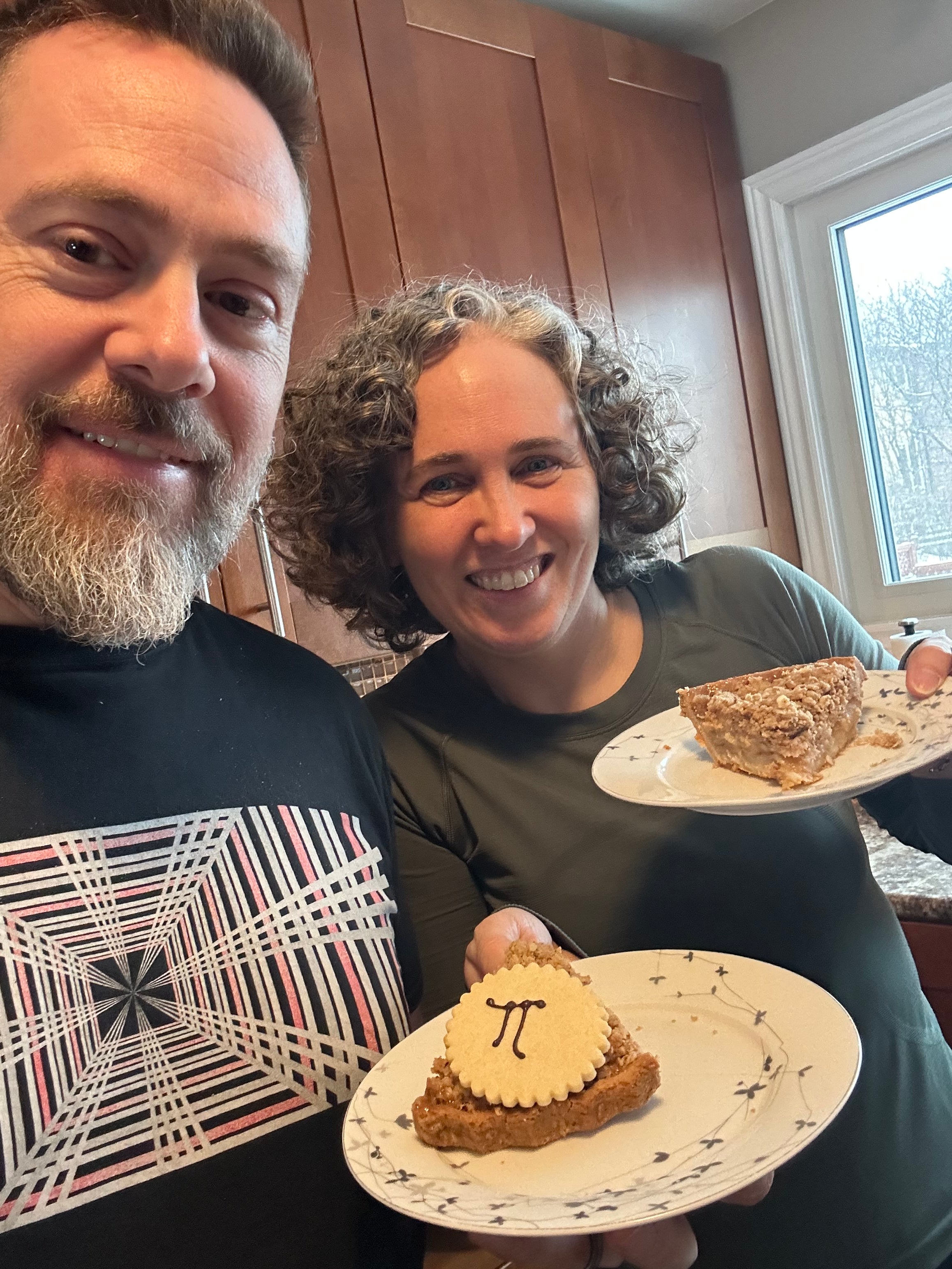 a man and a woman holding plates with pies on them