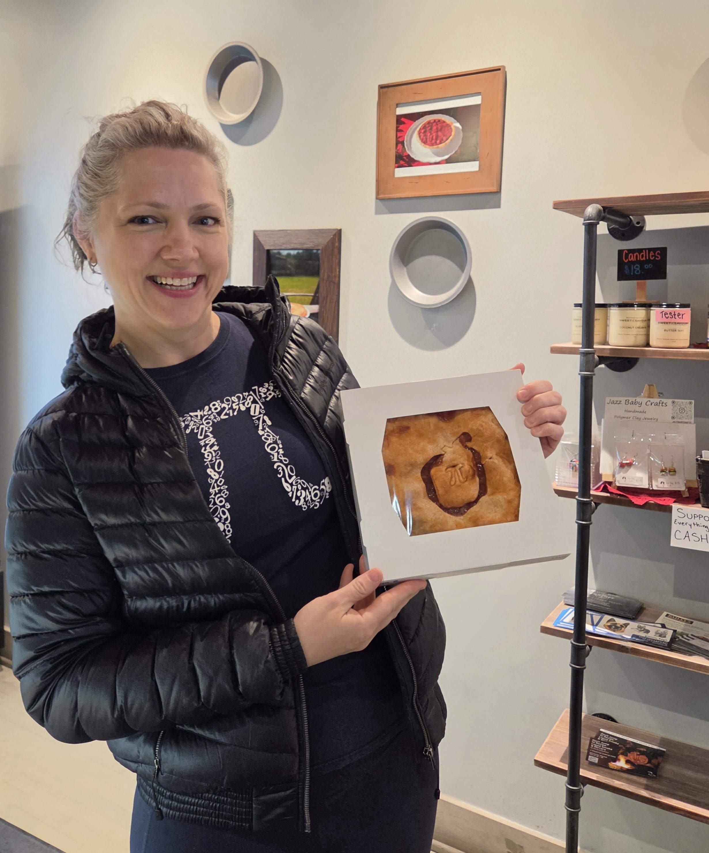 woman standing, smiling with a pie