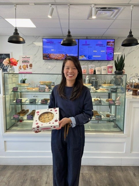 woman standing and smiling with pie