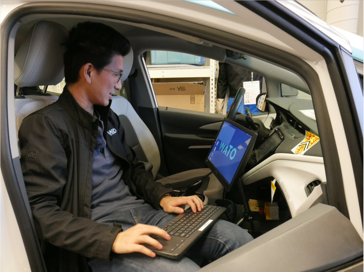 Charles Zhang interacting with a screen inside the Watonomous vehicle