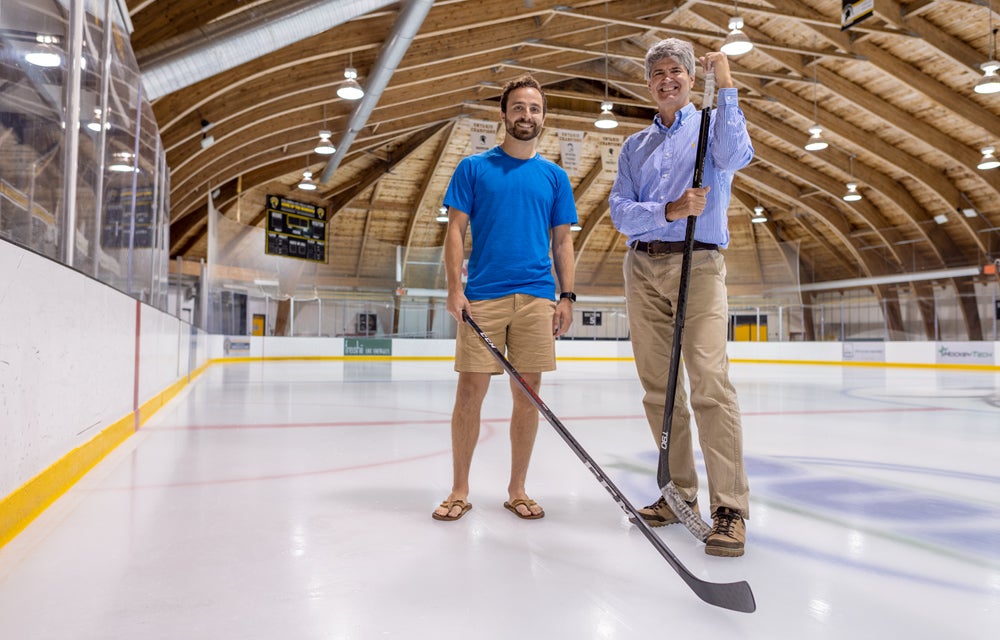 L to R: PhD candidate David Radke and his co-supervisor, Professor Tim Brecht standing on a hockey rink