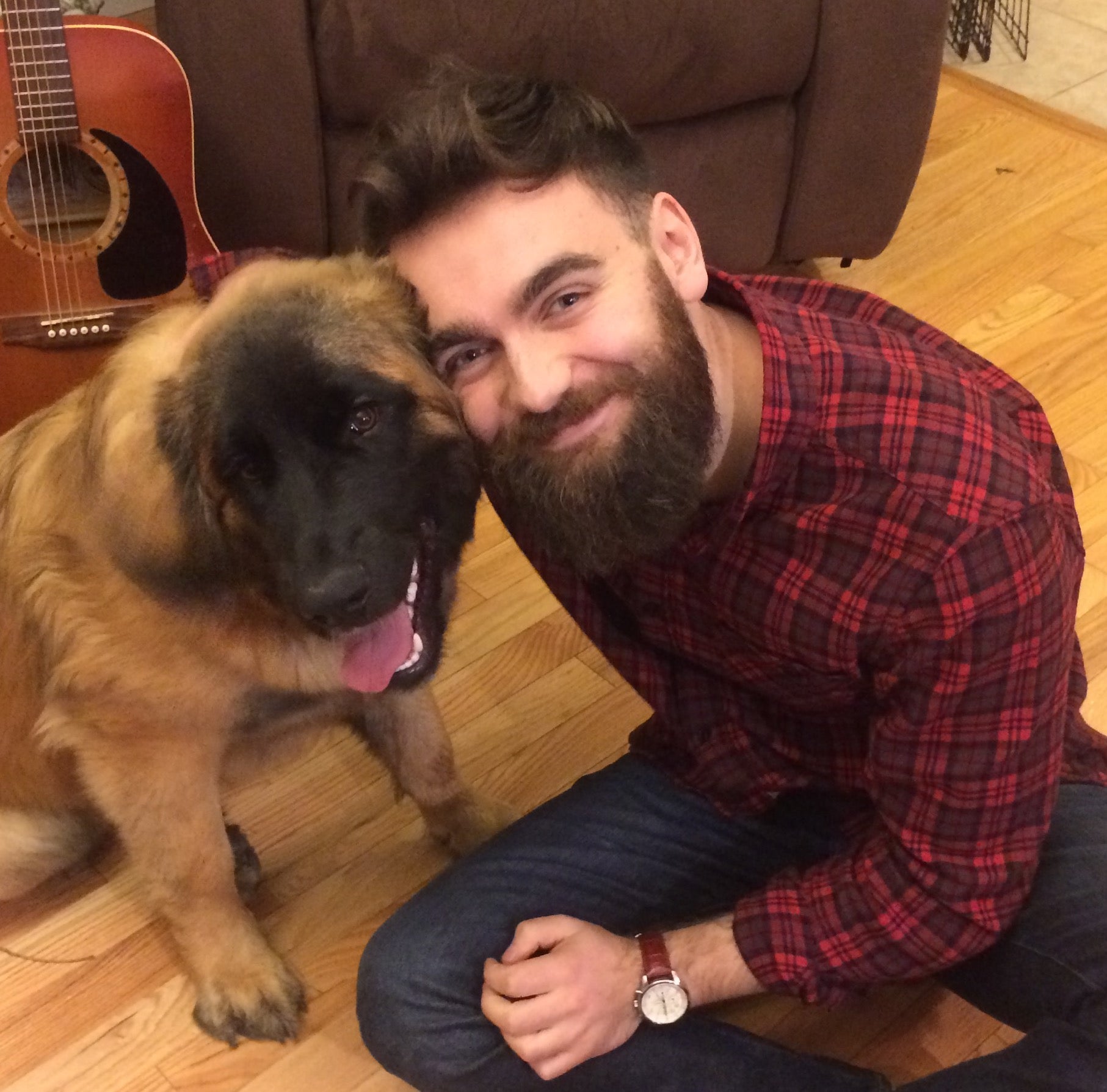 man with beard, smiling hugging his dog