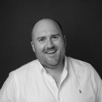 man wearing a white dress shirt smiling