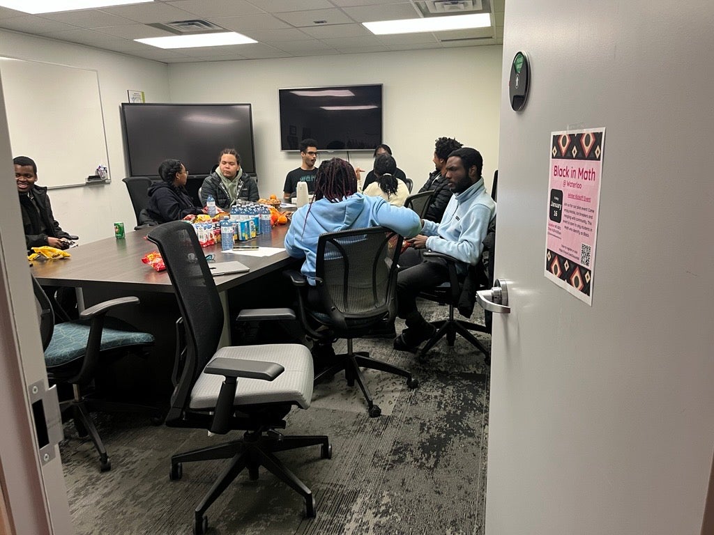 A group of people eating and talking to each other