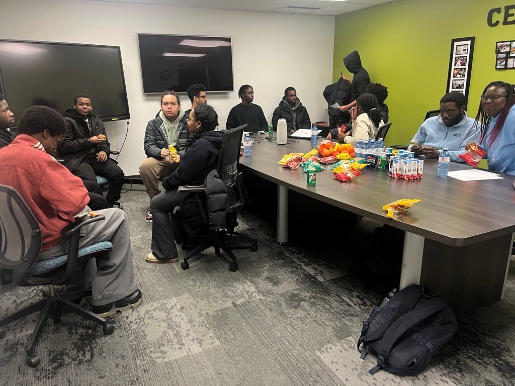 A group of people eating and talking to each other